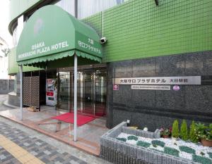 大阪大阪守口广场酒店 的一座建筑前面的商店,有绿色遮阳篷