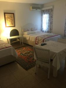 博德鲁姆帕夏汽车旅馆 的一间卧室配有两张床和一张桌子及椅子