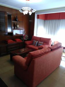 乌贝达Excelente apartamento 3 hab的客厅配有红色的沙发和桌子