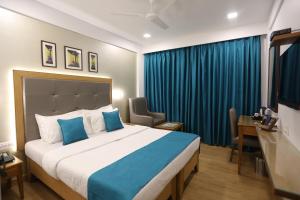 孟买星辰饭店的一间卧室配有一张大床和蓝色窗帘