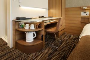 东京滨松町京王布莱索经济型酒店的酒店客房配有书桌和床。