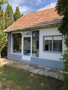 Balatonszabadi FürdőtelepRetro ház的一间白色的小房子,有红色的屋顶