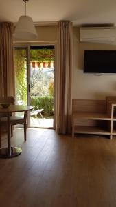 格雷乌莱班卢帕拉度酒店的客厅配有电视、桌子和桌子