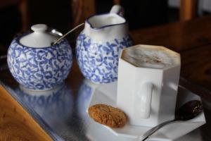 WolmaranstadDie Geel Huis Guesthouse的一张桌子,上面有两只蓝白花瓶和饼干