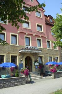罗滕堡罗藤伯格酒店的粉红色的酒店前面有蓝色的伞