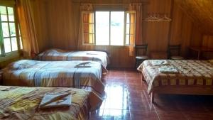 奥克萨潘帕La Casa Oxapampina的带窗户的客房内的三张床