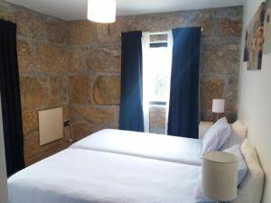 拜昂Casa de Mirão的卧室配有白色的床和窗户。
