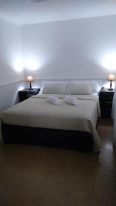 圣卡洛斯-德巴里洛切Departamento Céntrico en San Carlos de Bariloche的一间卧室配有一张大床,桌子上放着两盏灯