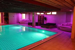 西泰尔斯海灵Wellness Suites Dellewal的紫色灯光客房内的游泳池