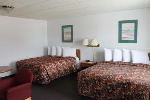苏圣玛丽Budget Host Crestview Inn的酒店客房,设有两张床和一张红色椅子