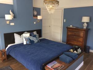 埃因霍温Florentino的一间卧室配有一张带蓝色墙壁和吊灯的床。