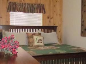 大熊湖Cabin on the Corner的一间卧室配有一张带桌子和窗户的床