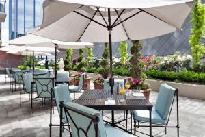 温哥华艾米塔什酒店的庭院里配有桌椅和遮阳伞