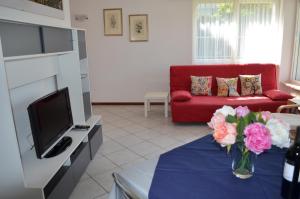 托尔博莱Ospitalità in zona panoramica的客厅配有红色的沙发和花瓶