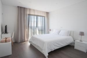 Companhia de CimaPortal dos Vimes AL的白色的卧室设有一张大床和一个窗户