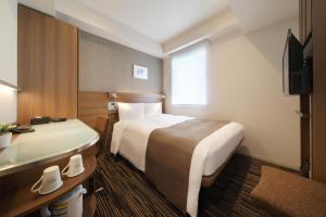 东京滨松町京王布莱索经济型酒店的酒店客房设有两张床和电视。