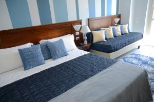 都灵凯撒大帝酒店的一间卧室配有两张带蓝白色枕头的床