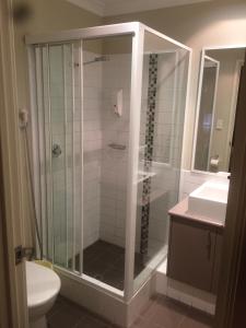 曼哲拉防波堤短住公寓的带淋浴、卫生间和盥洗盆的浴室