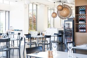 耐莉湾蓝色辣椒酒店的餐厅设有桌椅和窗户。