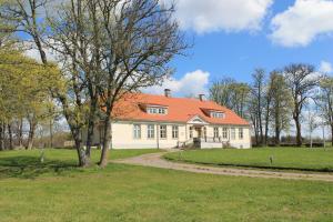 KihelkonnaLoona Manor Guesthouse的一座白色的大房子,有橙色的屋顶