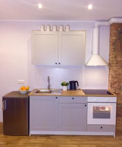 塔林Suur-Ameerika Apartment的厨房配有白色橱柜和水槽