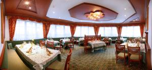 塞尔瓦迪加尔代纳山谷科洛那克朗酒店的用餐室设有桌椅和窗户。