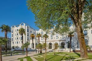 达克斯布鲁斯普伦迪酒店的一座白色的大建筑,前面有棕榈树
