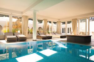 施托尔贝格哈尔茨施德尔布赫自然度假酒店的一座大游泳池,里面设有长沙发和椅子