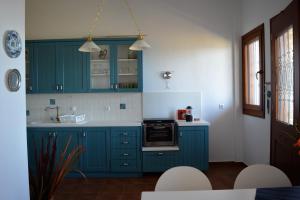 阿莫利亚尼岛Marvelous Sea View Eco Apt的厨房配有蓝色橱柜和白色台面