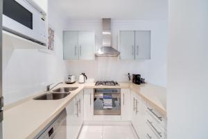 阿德莱德格伦费尔约克公寓的白色的厨房配有白色橱柜和水槽