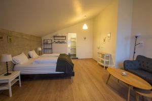 Vogur沃格尔乡村旅舍的一间卧室配有一张床、一张沙发和一张桌子