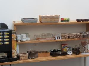 埃塔普勒奥帕尔海岸酒店的厨房配有带餐具和微波炉的木制架子
