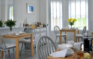 布德Surf Haven的厨房配有白色橱柜和桌椅