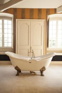 Saint-Martin-en-Bière多美因巴比宗旅馆的带窗户的客房内的白色浴缸