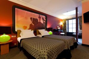 巴黎枫丹酒店的酒店客房设有两张床,墙上挂着一幅大画。