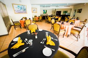 金斯敦阿尔塔蒙特苑酒店的用餐室配有带黄色餐巾的黑色桌子