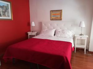 马泰拉心里马泰拉度假屋的红色卧室配有一张带红色毯子的白色床