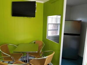 旧奥查德比奇Lighthouse Cabins的绿色客房配有桌子和冰箱