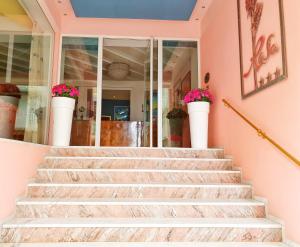 加比切马莱Residence Rosa的一座房子的楼梯,里面装有粉红色的墙壁和鲜花