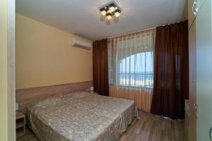 金沙Sea Panorama Apartments Golden sands的一间卧室设有一张床和一个大窗户