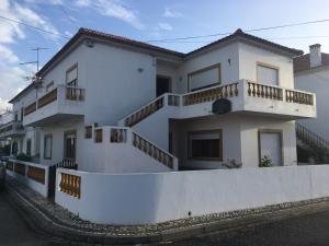 阿尔莫格拉维Refúgio do Almograve的白色房子的一侧设有阳台