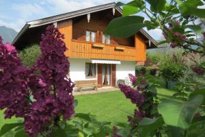 伦格里斯Gästehaus Peter Wiedemann的一座带花园和紫色鲜花的房子