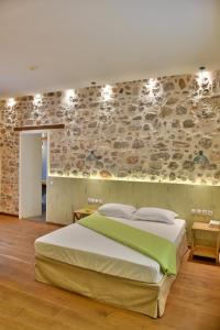 伊兹拉Manolia的一间卧室设有一张大床和石墙