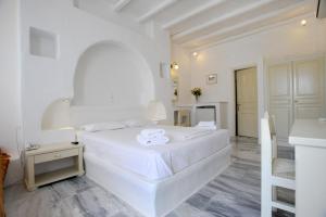 圣约阿尼斯卡罗简易别墅酒店的一间白色卧室,配有一张大床和一个厨房