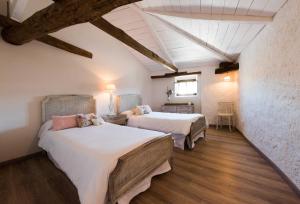 贝尔蒙特La Casa de la Vieja - Alojamiento Rural 3 y 4 Estrellas的铺有木地板的客房内的两张床