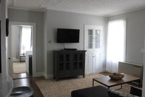 沃尔夫伯勒New One Bedroom Apartment Near Lake Winnipesaukee的客厅设有壁挂式平面电视。