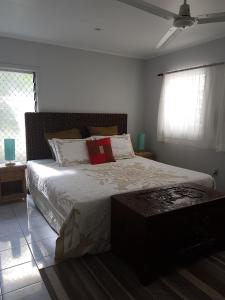 拉罗汤加日落码头酒店的一间卧室设有一张大床和一个窗户。