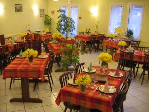 Saint-Martin-sous-VigourouxHotel De La Poste的用餐室配有桌椅和鲜花