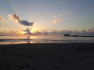 蜜岛Pousada Villa Maria的日落在海滩上与大海