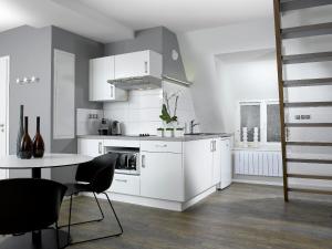 斯特拉斯堡32套公寓酒店的厨房配有白色橱柜和桌椅